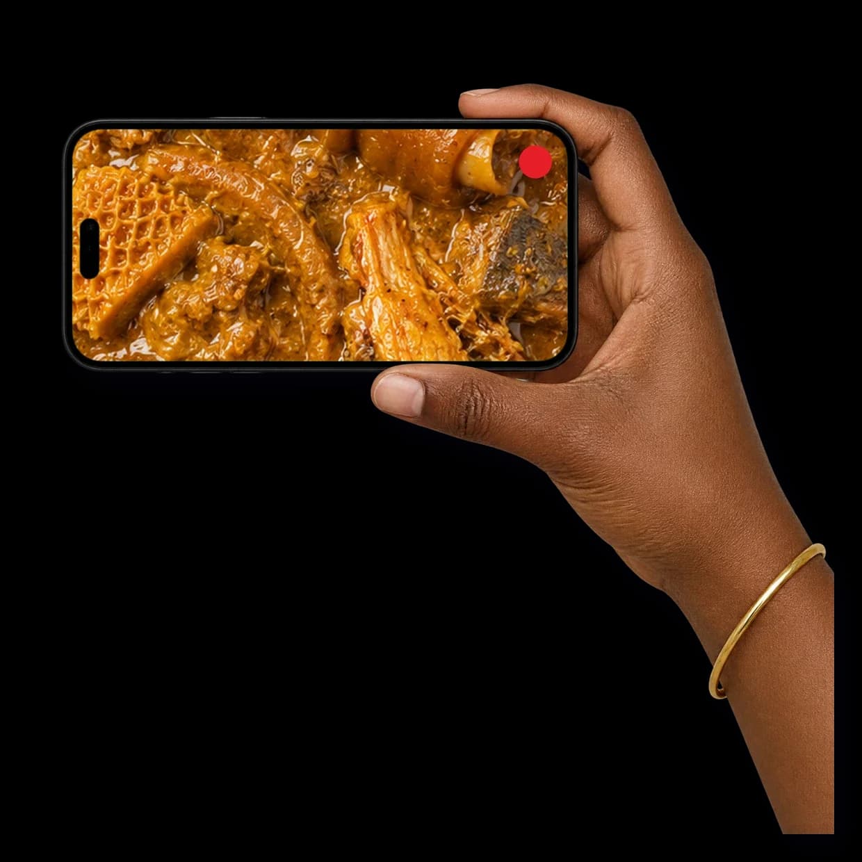 A hand filming a pot of stew on a phone held sideways